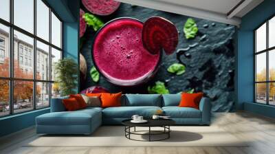 A vibrant beetroot juice in a glass, surrounded by fresh beets and greens on a dark surface. Wall mural