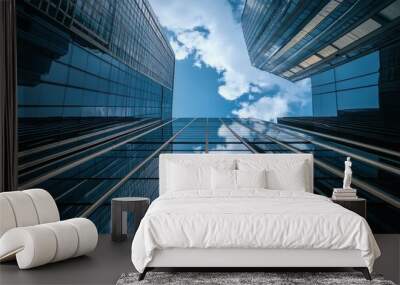 A view looking up at modern skyscrapers reflecting the sky. Wall mural