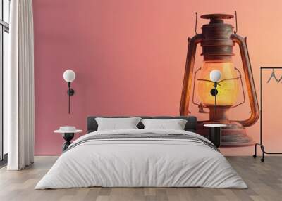 A vintage lantern emitting a warm glow against a soft pink background. Wall mural