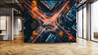 Aerial view of a busy urban intersection illuminated by vehicle lights at night. Wall mural