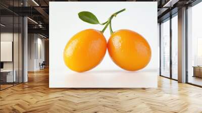 Two bright orange kumquats with green leaves on a white background. Wall mural