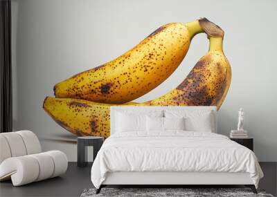 Two ripe bananas with brown spots on a light background. Wall mural