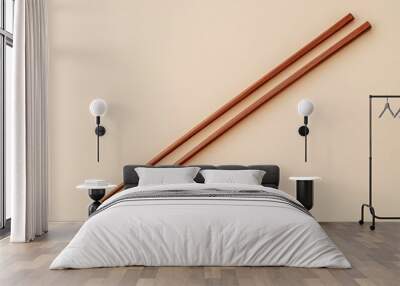 Two wooden chopsticks placed parallel on a light background. Wall mural