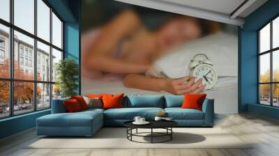 Blurry, the woman was irritated by the loud sound of an alarm clock in the morning in his home. Wall mural