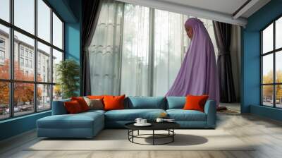 Muslim women praying In the foyer of the house during the coronavirus (COVID-19) outbreak, quarantine concept. Wall mural