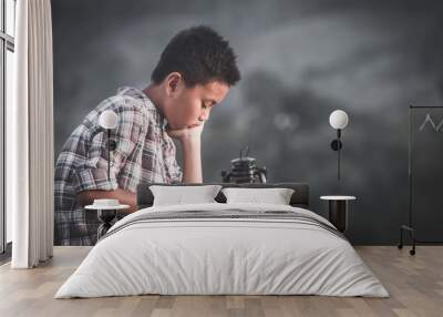 Boy reading bible with light of oil lamp, christian concept. Wall mural