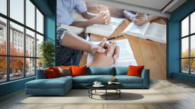 christian group share bible with praying on wooden table, prayer meeting concept. Wall mural