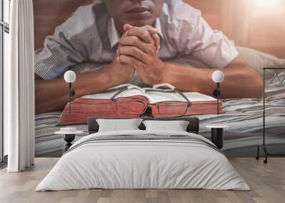 Close up holy Bible with young male reading and praying in morning on bed. christian concept. Wall mural