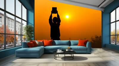 Human holding and lift the Bible up with light sunset background, christian silhouette concept. Wall mural