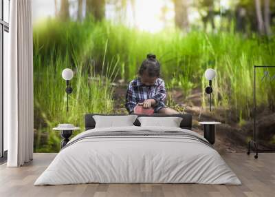 Little girl praying and holding holy Bible in nature. christian concept. Wall mural