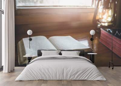 open bible for read in morning devotion on wooden table with window light Wall mural