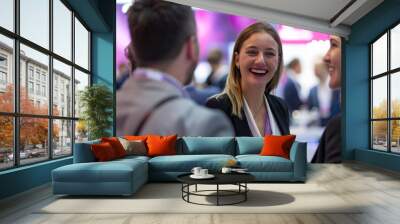 A candid shot of a woman conversing at a trade fair, gaining valuable experience and knowledge from industry experts. Wall mural