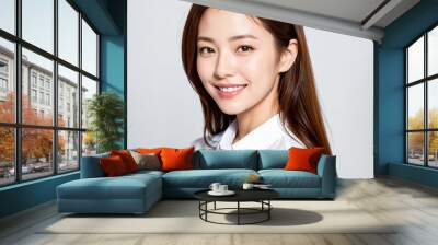 A charming Asian girl with a friendly demeanor dons a white shirt as she looks directly at the camera, her warm smile radiating joy and positivity. generative AI. Wall mural