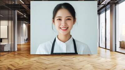 A professional series featuring young women in uniforms and aprons, with their friendly expressions and simple background making these images perfect for service industry promotion. Wall mural