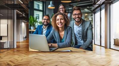 A team of professionals, both men and women in a modern office, showcasing their enthusiasm and camaraderie as they pose for a group photo while working on laptops. generative AI. Wall mural