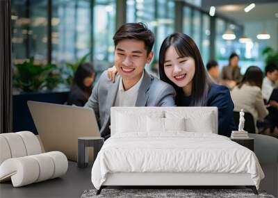 Asian couple working and researching online on laptop, Cheerful loving young couple using laptop analyzing work. Beautiful couple working on a tablet at office. Generative AI.. Wall mural