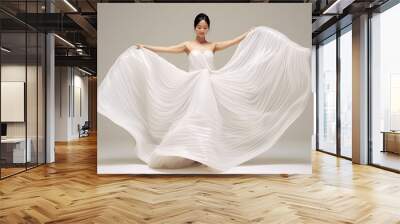 Beautiful woman wearing flowing white dress and pose dancing over a light background. Generative AI. Wall mural