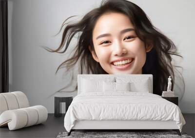 Charming Asian teenager with long hair blowing in the breeze exudes positivity with a bright smile on a white background. generative ai. Wall mural