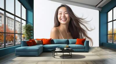 Charming Asian teenager with long hair blowing in the breeze exudes positivity with a bright smile on a white background. Wall mural