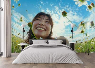 In a flower-filled garden, an attractive Asian woman with a captivating and charming face is captured laughing joyfully in the morning light. Wall mural