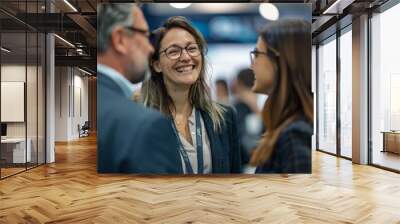 individuals in business casual attire as they laugh and chat together at an exhibition booth after the fair concludes captures the genuine connection and happiness shared among friends. Wall mural