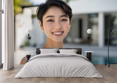 Standing beside a clear blue pool, a serene young Asian woman’s simple white top and gentle smile capture the essence of elegance and tranquility in a luxurious setting. Wall mural