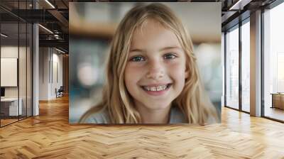 With a charming smile, Caucasian girl wearing braces sits in orthodontist's office, her gaze directed at camera as she focuses on her tooth and bracket, background softly blurred. Wall mural