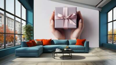 Photo female hands hold a small gift box on a white table background top view  Wall mural