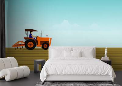  tractor in field.The man is driving a orange tractor. In order to plow the soil in the field. Have a blue sky background Wall mural