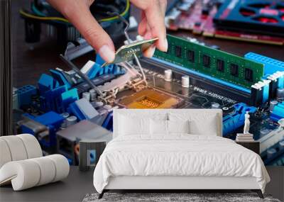 Engineers are placing the CPU on the sockets of the computer motherboard. Wall mural