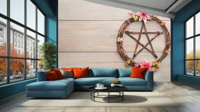 Pentacle Wreath with Pink Flowers on Rustic Wooden Background. Wall mural