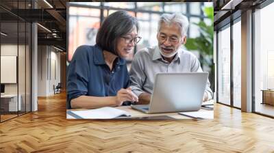 Two happy professional coworkers discussing online plan at work. Mid aged manager explaining Asian colleague financial project on laptop. Diverse business people using computer in at, Generative AI Wall mural