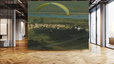 Paraglider are flying in the sky over the fields Wall mural