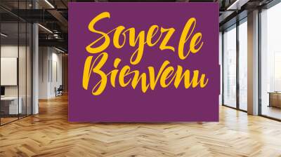 Bright yellow French Soyez le bienvenu inscription on purple background Wall mural