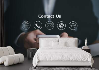 Contact us or Customer support hotline people connect. Businessman using a mobile phone with the email, call phone, address, Chat message icons. Wall mural