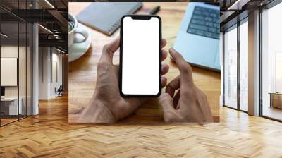 man hand using smartphone In the office Screen blank with clipping path ,Top view mockup image of male holding mobile phone with empty white screen Wall mural