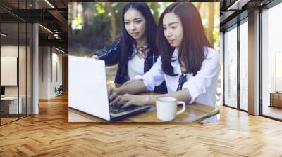 two asian girl working with laptop computer on the wood desk Wall mural