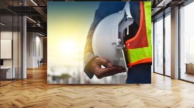 Technician holding white hat safety hard hat sunlight background Wall mural