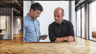 Two people looking on smartphone to trading online Wall mural