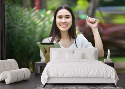 Women using tablet filling happy smile to shopping online at city park Wall mural