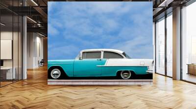 Antique car on display against a cloudy deep blue sky Wall mural