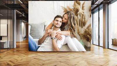 Lovers hug each other in the large bedroom. Love story. Wall mural