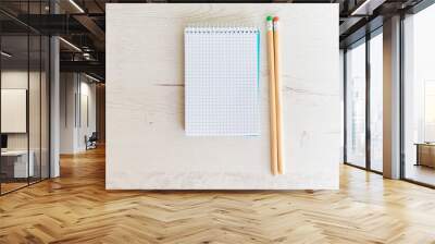 notebook with a blank sheet and two colored pencils on a light background

 Wall mural