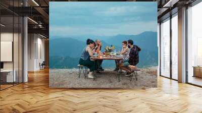 Friends and family gathered for picnic dinner for Thanksgiving. Festive young people celebrating life with red wine, grapes, cheese platter, and a selection of cold meats Wall mural