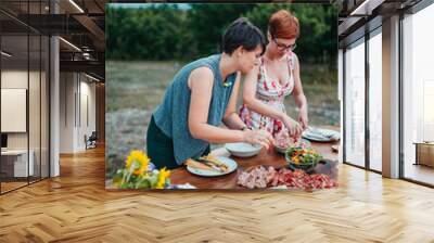 Two friends setting the table for rustic dinner in nature Wall mural