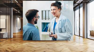 Woman Doctor talking to Patient at her Medical Office Wall mural