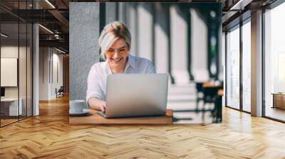 Young woman drinking coffee and checking email Wall mural