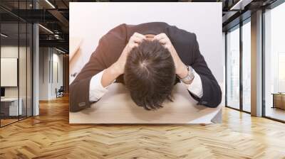 Handsome business man bend down the head on overtime work and stresses. Wall mural