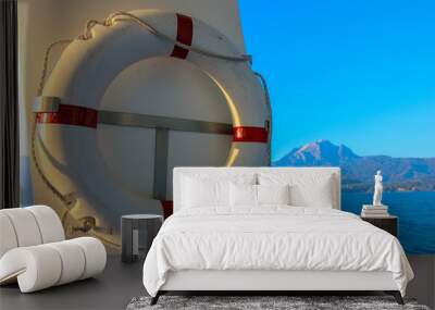 red and white safety torus or lifebuoy hanging on the boat Wall mural