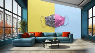 colorful pink and black fashion face mask handmade from fabric cloth on blue and yellow background Wall mural